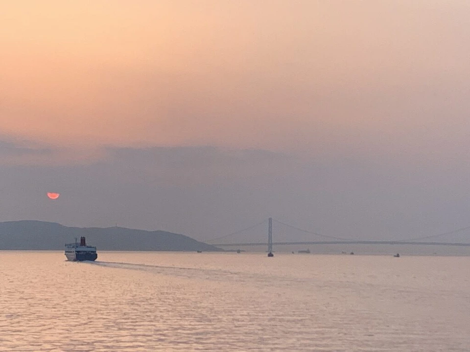 夕日が沈む海と遠くの島影