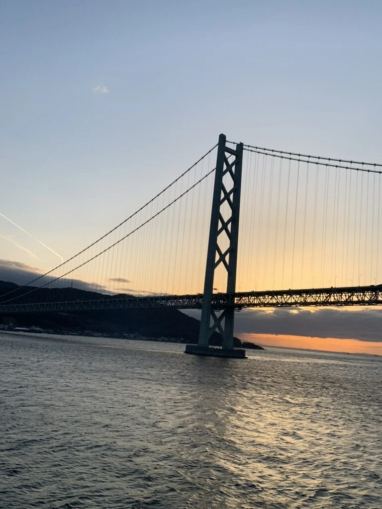 夕焼け空に主塔のシルエットが浮かぶ明石海峡大橋
