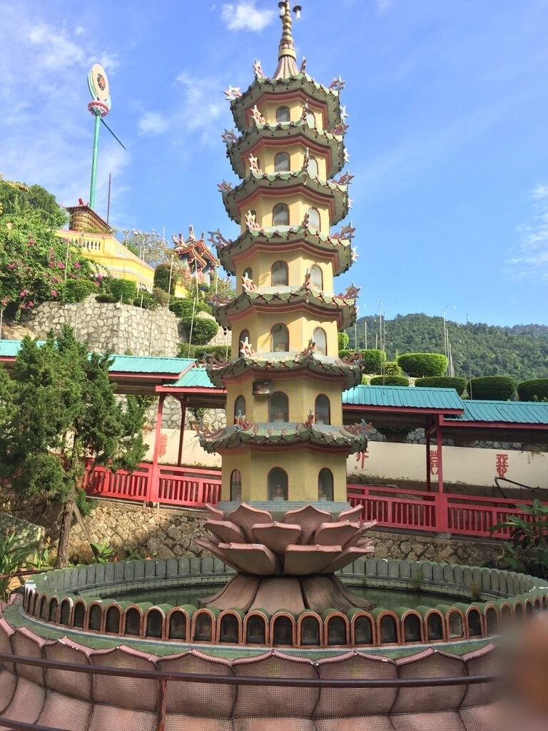 極楽寺の蓮の花の台座に載った多層の小さな塔と池