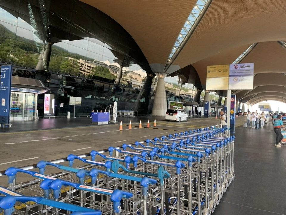 KLIA出発階の車寄せ。大きな屋根の下に青い荷物カートが並ぶ