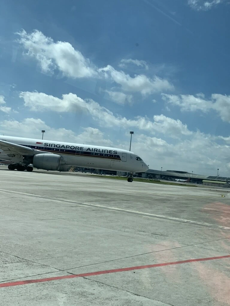 KLIAのガラス越しに見た駐機場のシンガポール航空機と青空
