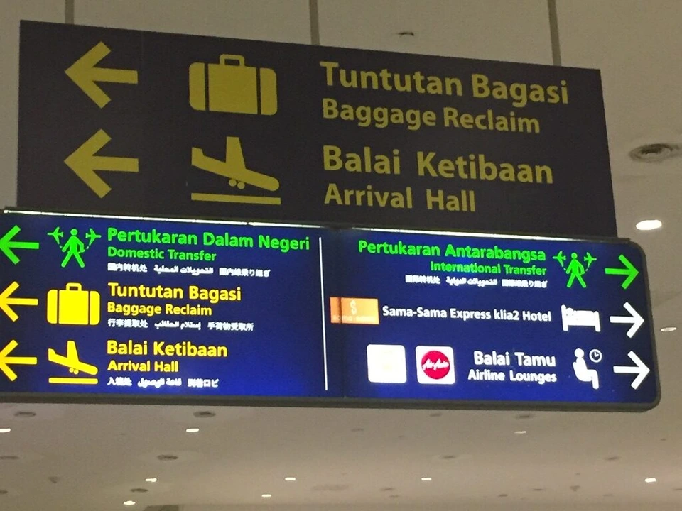 KLIA2の案内板。手荷物受取、到着ホール、国内線乗り継ぎ、国際線乗り継ぎの矢印
