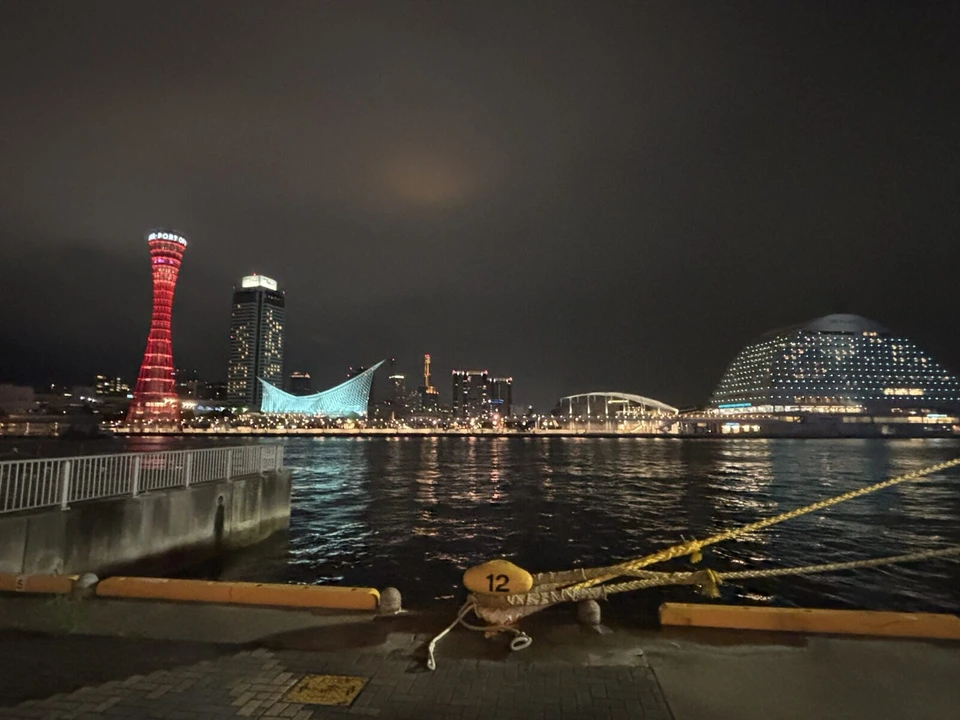 岸壁のロープと係留柱の向こうに、ポートタワー、海洋博物館、メリケンパークの白いホテルが並ぶ夜景