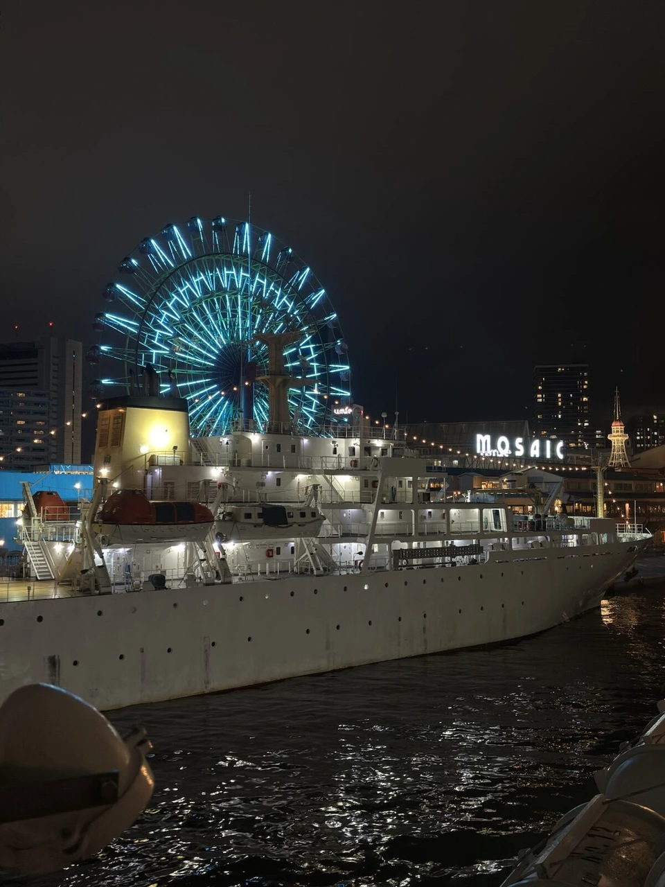 夜のハーバーランドの青い観覧車と白い船、MOSAICの文字の看板