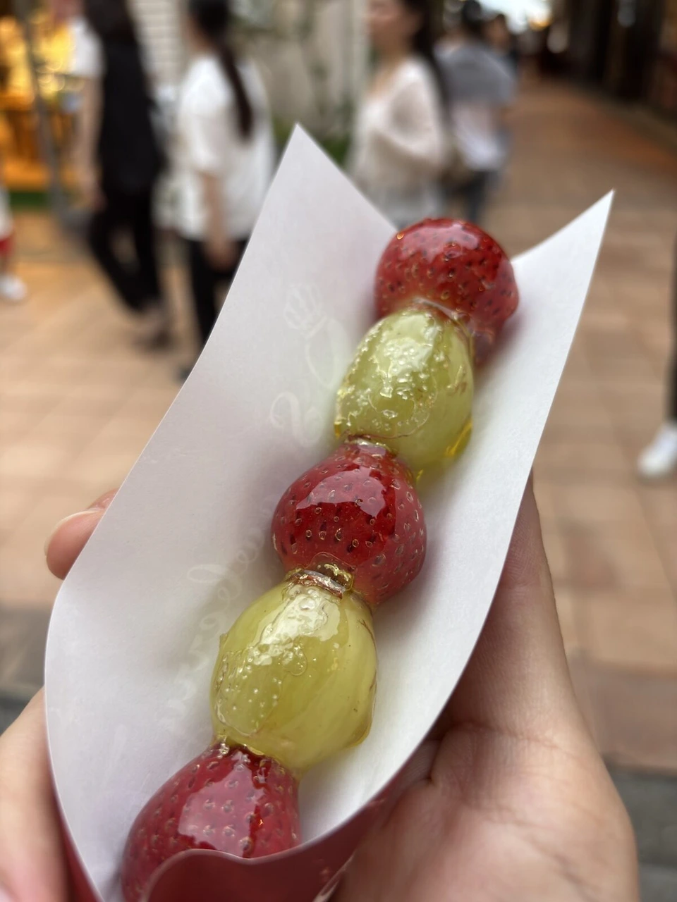 神戸ハーバーランドで買ったフルーツ飴の串。いちごと緑のぶどうが交互に刺さっている