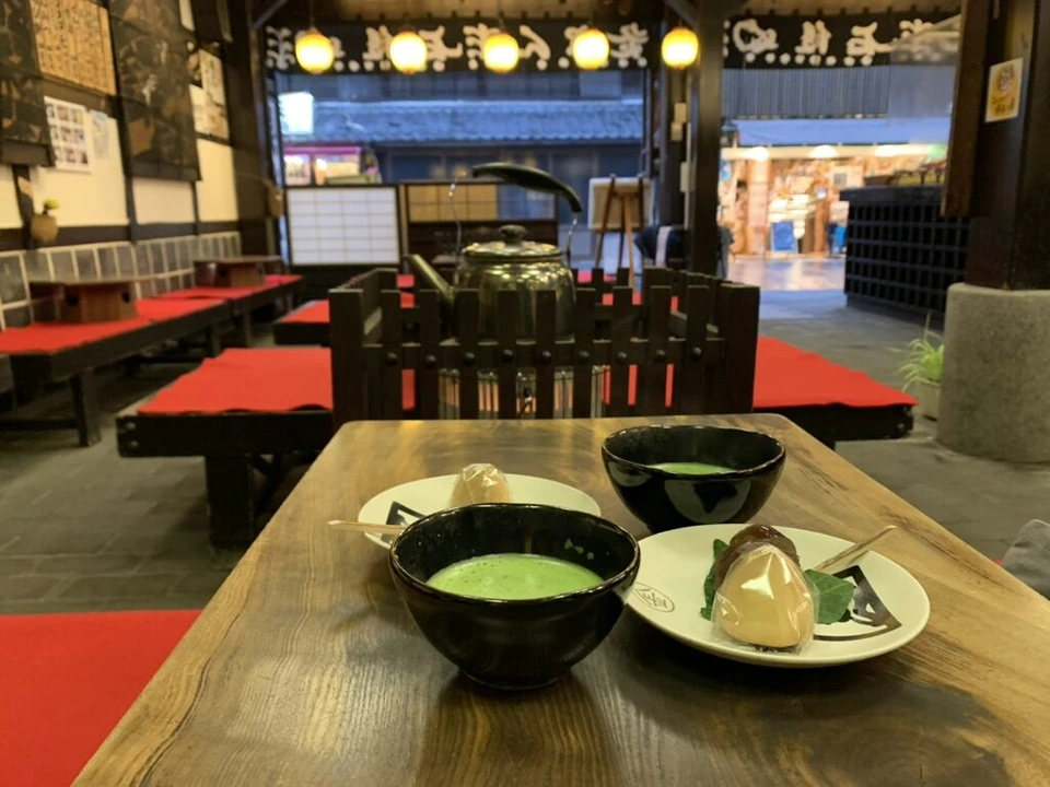 琴平の参道の茶店の席。抹茶と和菓子、赤い毛氈の縁台と大きなやかん