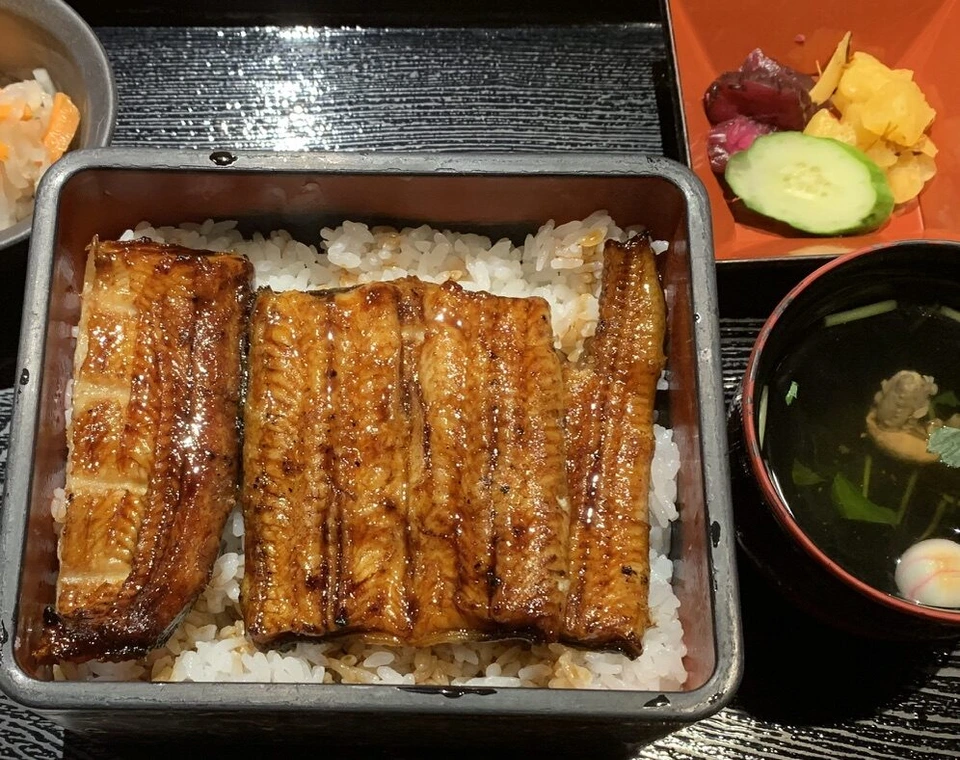 うな重のアップ。たれで照りのあるうなぎがご飯の上に並ぶ