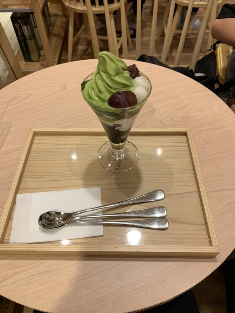締めに食べた抹茶ソフトのパフェ。木のトレーとスプーン3本