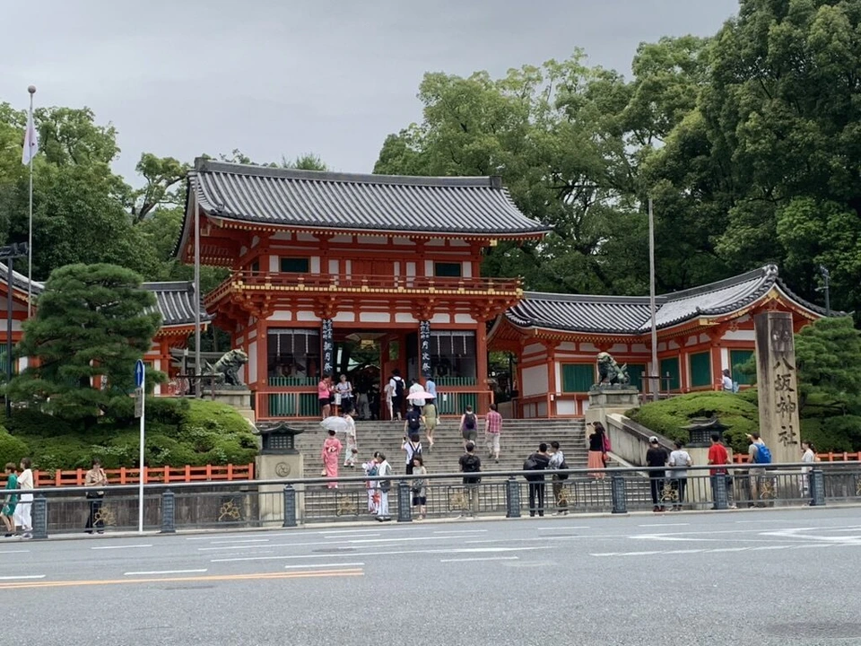 道路越しに見た八坂神社の西楼門と、石段を上り下りする参拝の人たち
