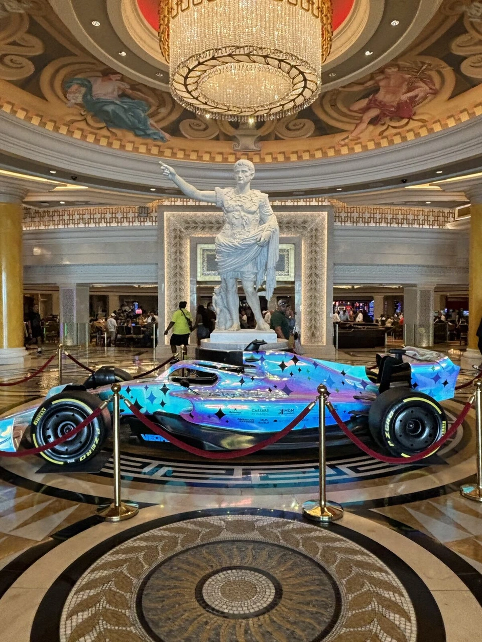 シーザーズ・パレスのロビー。シャンデリアの下の像と、青いF1マシンの展示