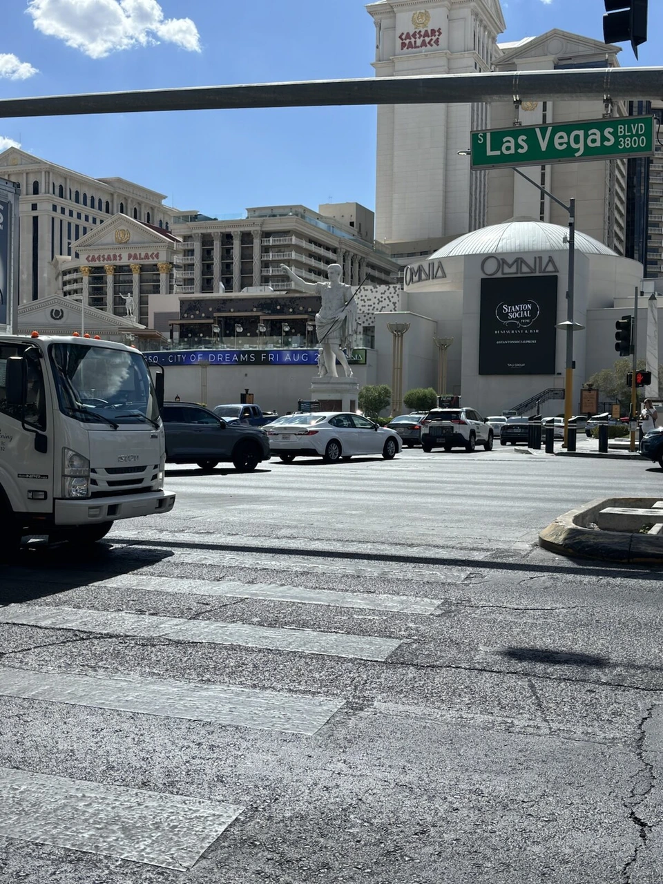 Las Vegas Blvdの標識がある交差点と、シーザーズ・パレスの建物、OMNIAの丸い建物