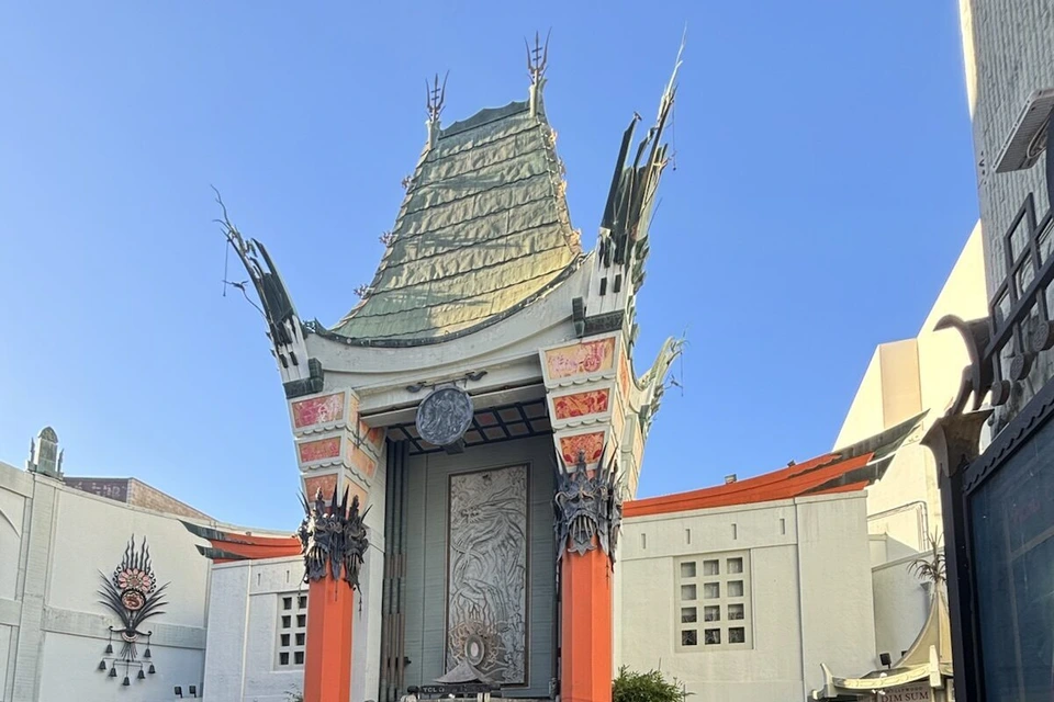 青空の下のTCLチャイニーズ・シアター。緑の屋根と赤い柱の中国風の正面