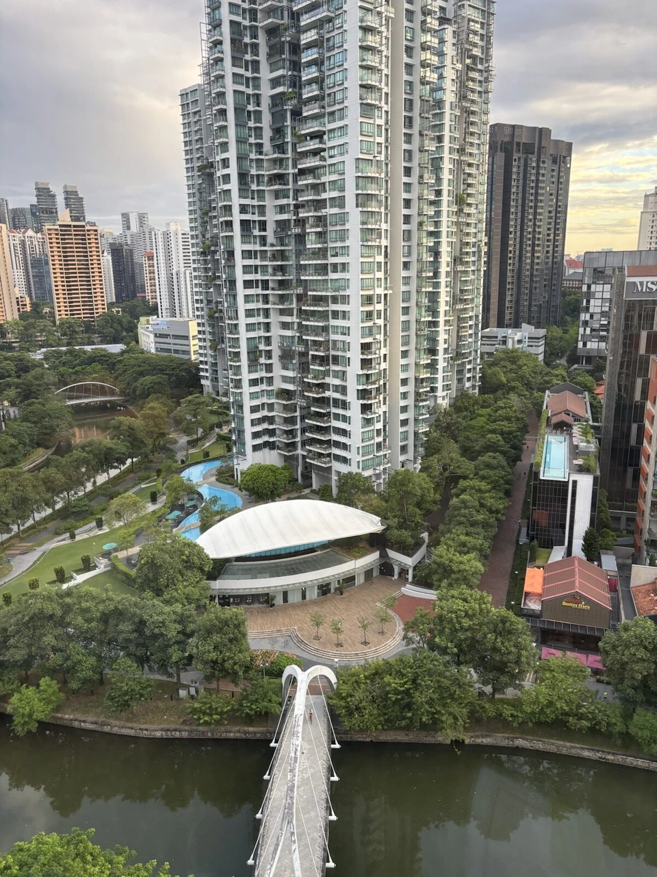 フォーポイント・シンガポール・リバービューの客室の窓から見たシンガポール川と白いアーチの橋、高層マンション