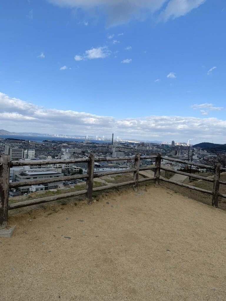 丸亀城の本丸の広場の端の柵と、その先に広がる街と空