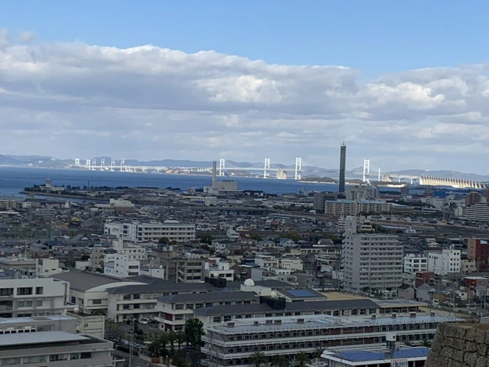 丸亀城の本丸から見た丸亀の市街地と、海に架かる瀬戸大橋