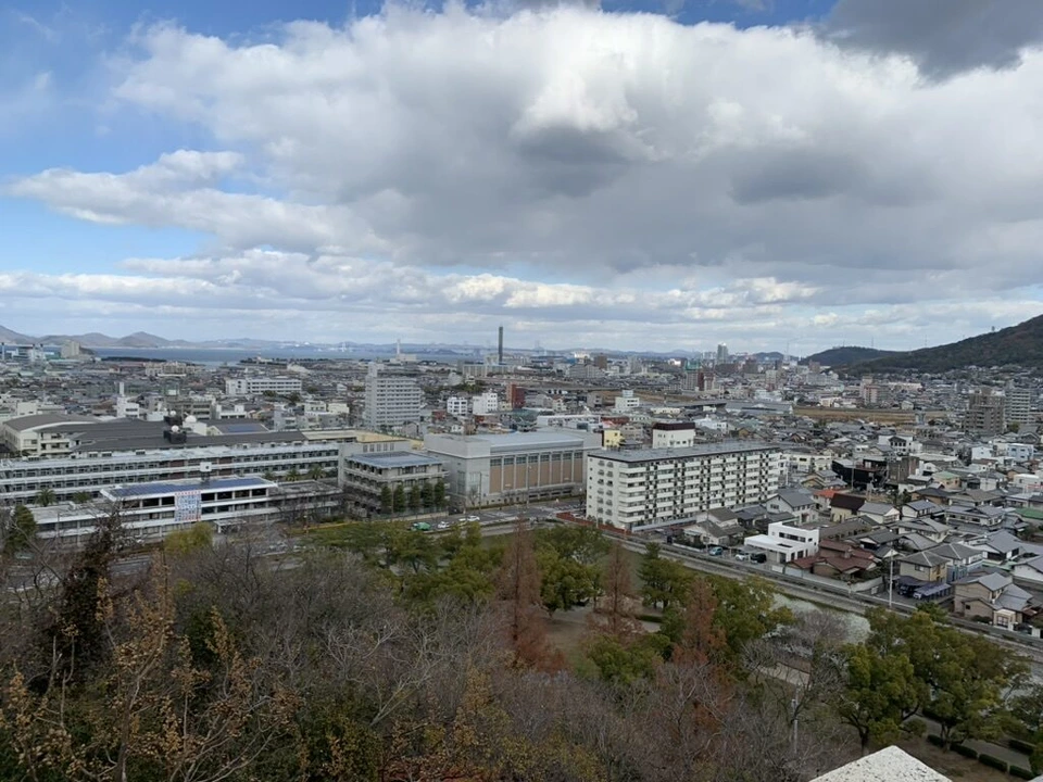 丸亀城の途中の石垣の上から見た市街地と山