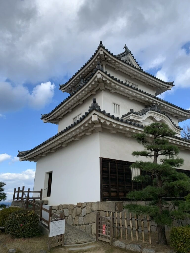 斜め下から見上げた丸亀城の天守と雲の多い空