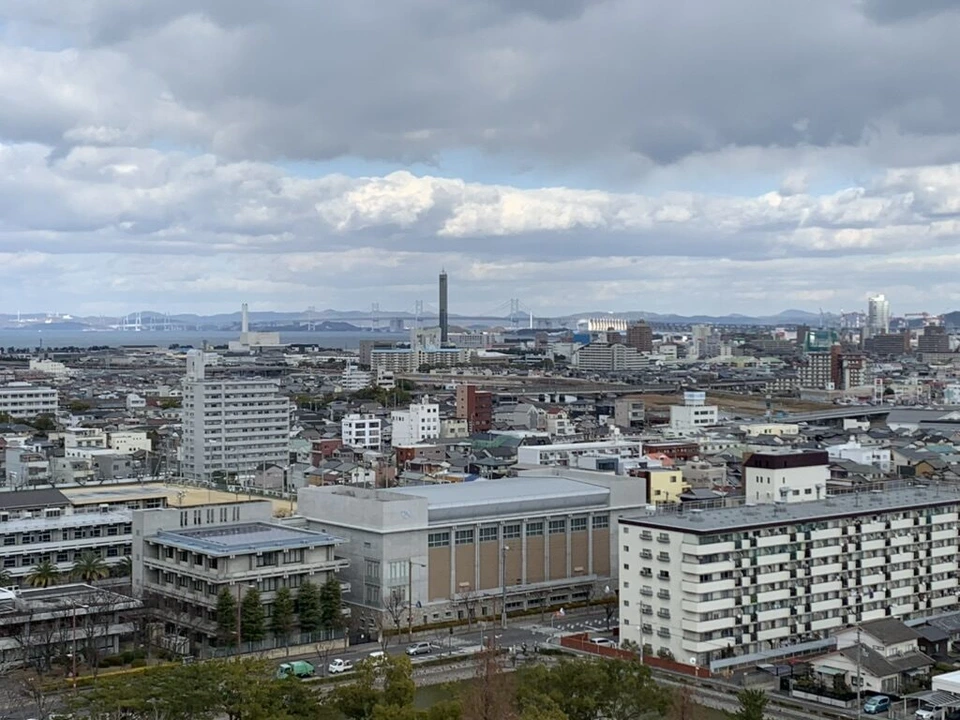 丸亀城の途中の石垣の上から見た丸亀の市街地と、遠くの瀬戸大橋