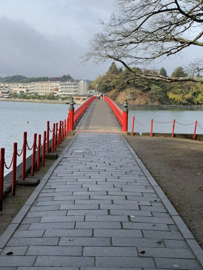 福浦島側の石畳の道と、朱色の柵、その先に橋
