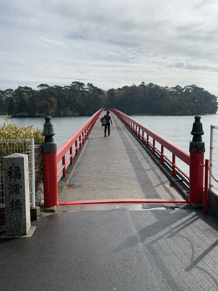 「福浦橋」の石柱と朱色の欄干の橋、先に福浦島