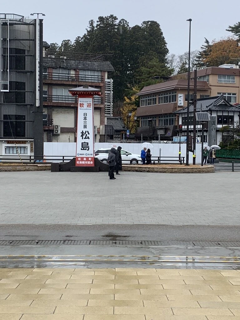 桟橋前の広場と「日本三景 松島」の標柱、奥に旅館の建物