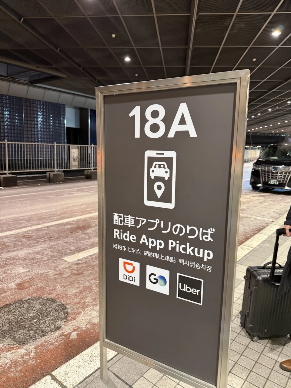 新千歳空港の国内線ターミナルの外にある配車アプリのりば18Aの看板。DiDi・GO・Uberのマーク