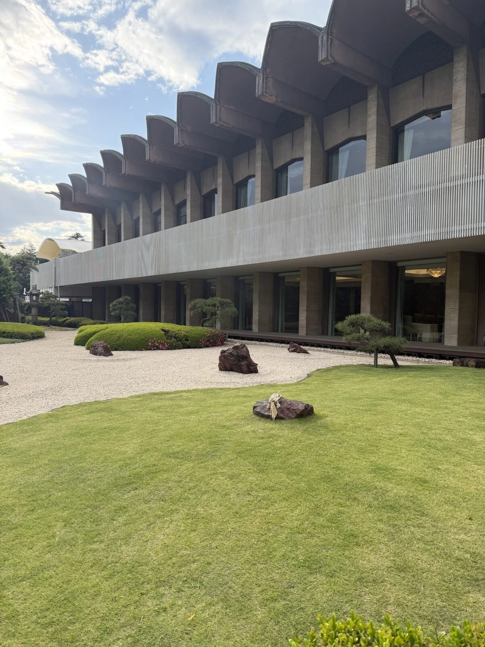 ホテルニューオータニの日本庭園。白い砂利と芝生、奥にのこぎり屋根のような形の建物