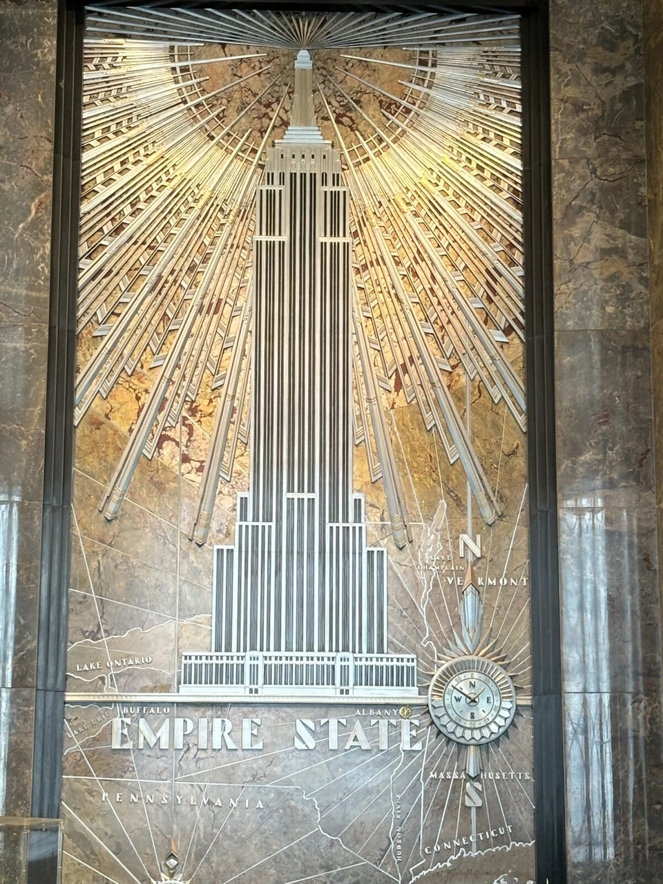 エンパイア・ステート・ビルのロビーにある、金色の光線とビルを描いたアール・デコのレリーフ