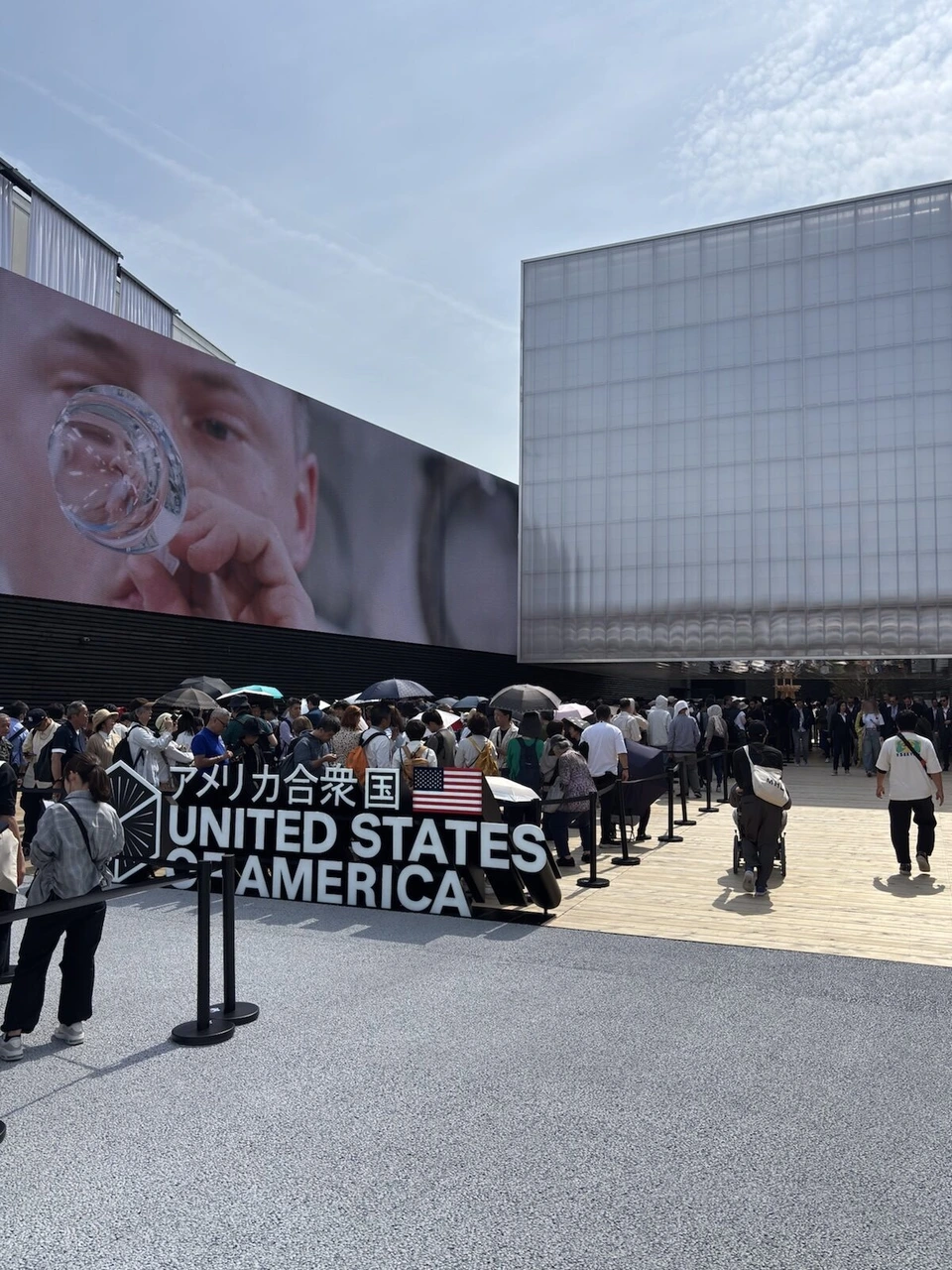 アメリカ合衆国館の前。UNITED STATES OF AMERICAの立体文字と、建物の横の大きな映像、入口に向かう長い列