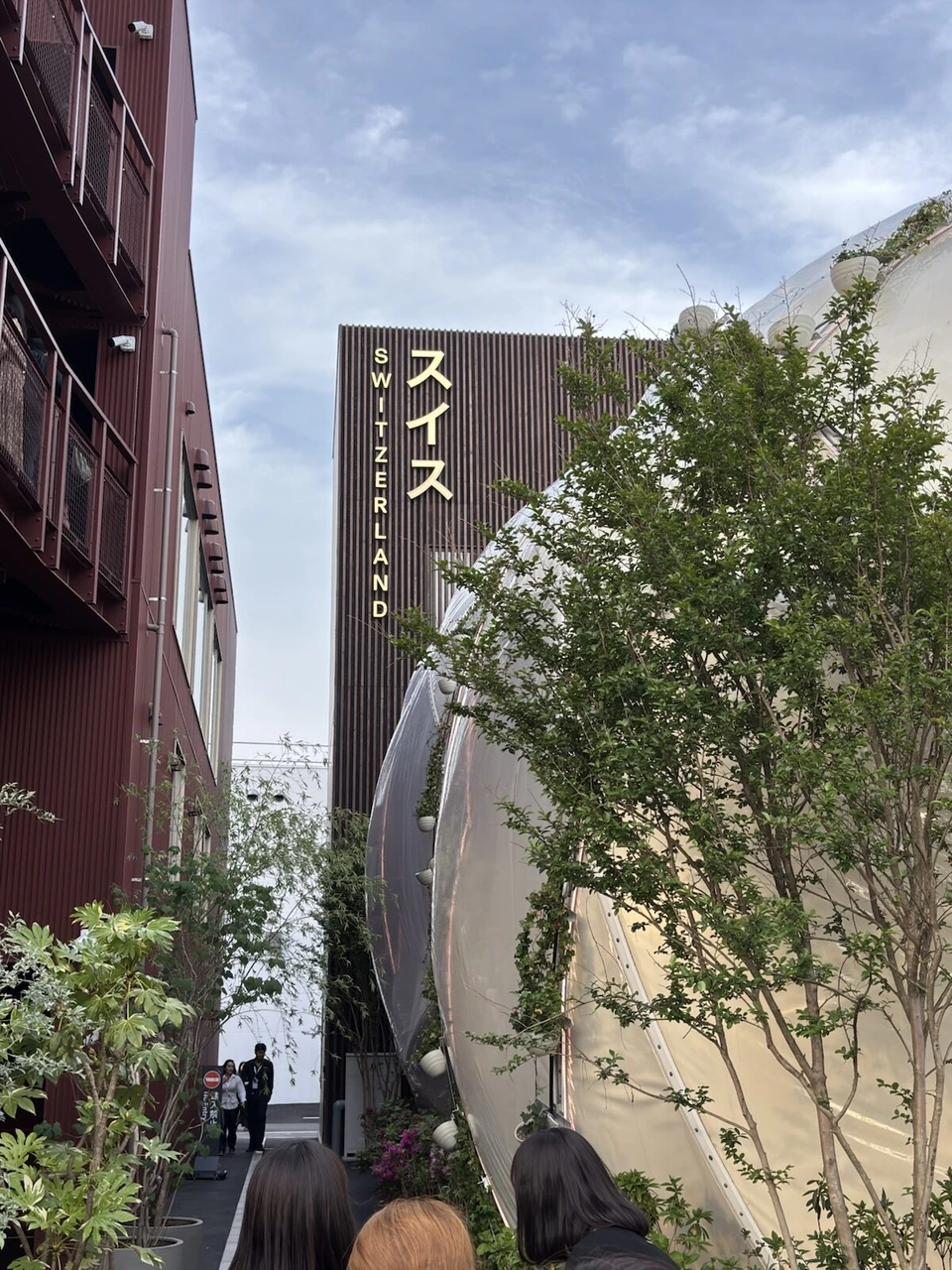 スイスの縦書きの看板と、白い風船のような球体の建物の一部