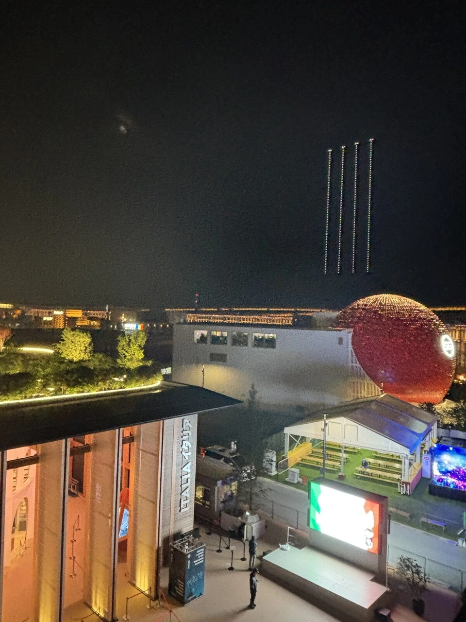 大阪・関西万博のドローンショー。夜の会場の上空に縦に並んだドローンの光