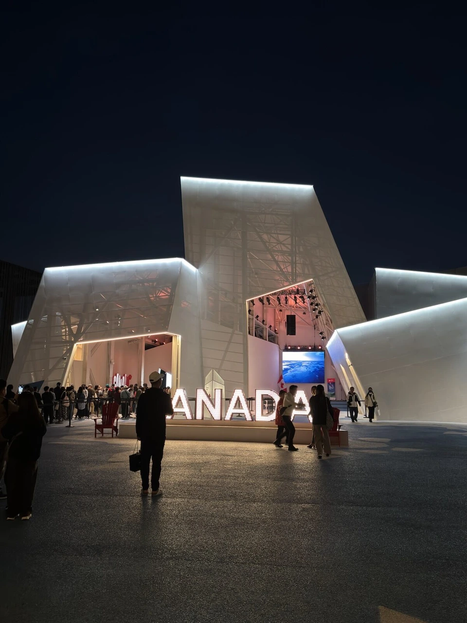 夜、白くライトアップされたカナダ館の尖った外壁とCANADAの文字