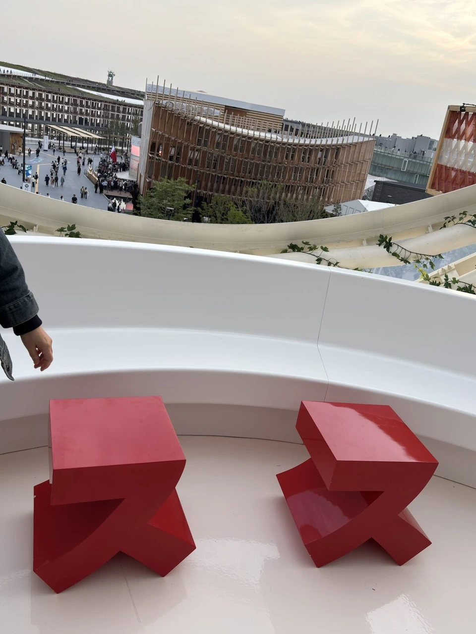 スイス館の上の階のカフェ。白いカウンターの前の赤いスツール2つと、その先の万博会場
