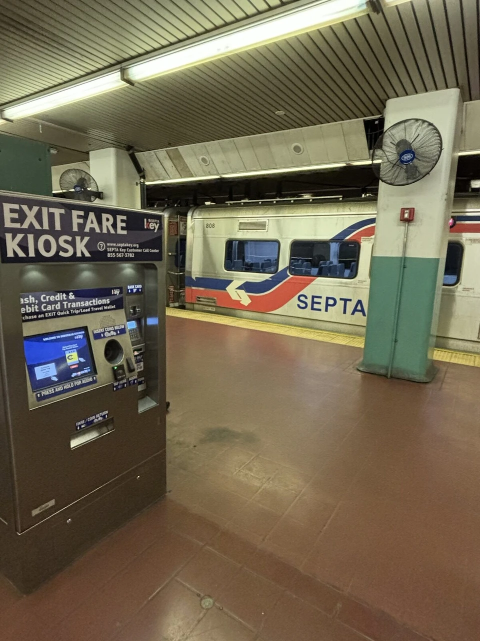 SEPTAの地下ホームにある運賃精算機EXIT FARE KIOSKと停車中の電車