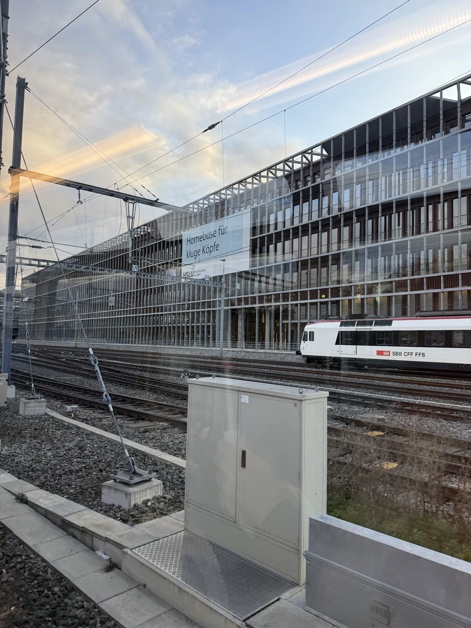 ルツェルン駅を出た列車の窓から見た線路と駅の建物、赤い列車