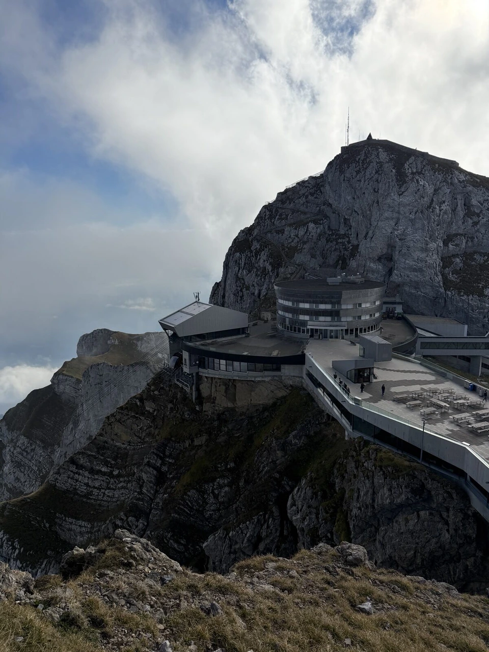 ピラトゥス山の山頂駅ピラトゥス・クルムの建物と、その上にそびえる岩山