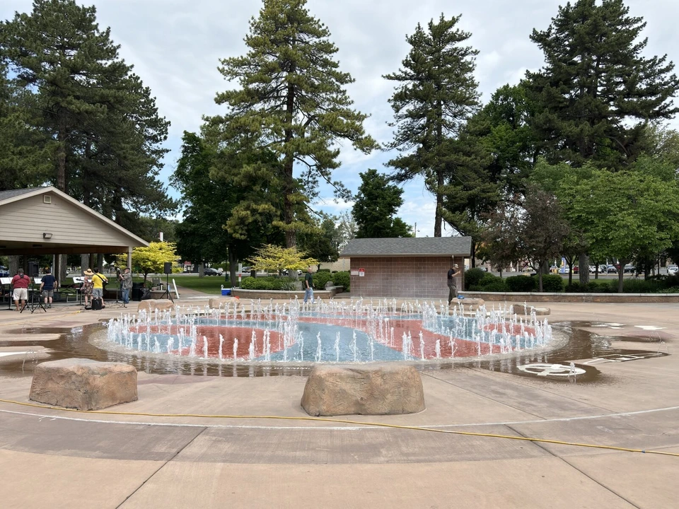 プロボ市役所近くの公園で床から水が噴き出す円形の噴水と、まわりの松の木
