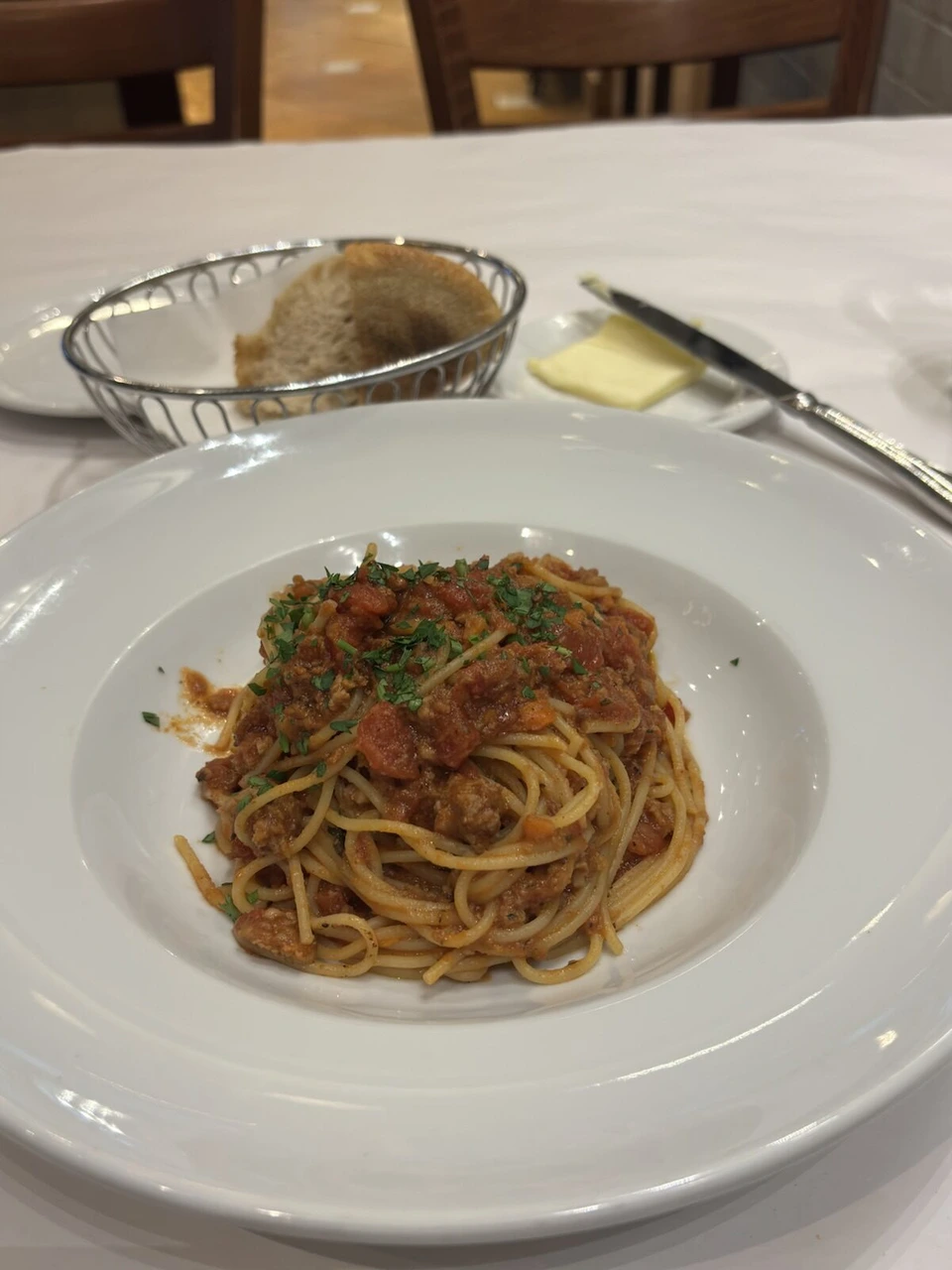 ソルトレイクシティのダウンタウンで食べた、白い皿のトマトソースのパスタとパンの入ったかご