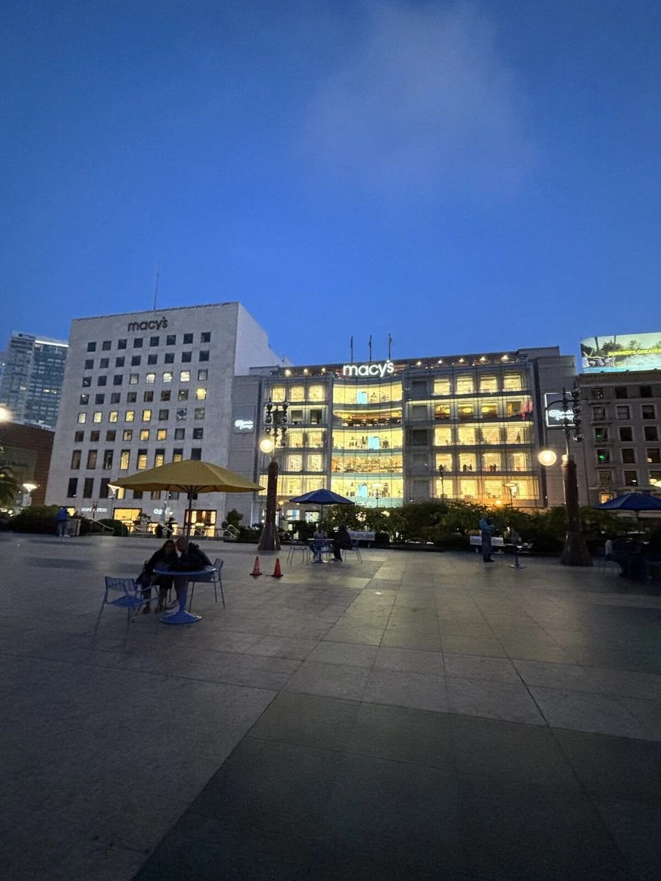 夕暮れのユニオンスクエアの広場と、明かりのついたメイシーズの建物