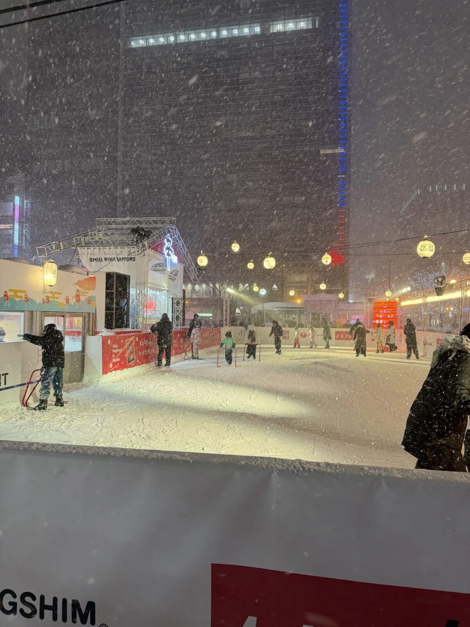 雪まつり大通会場3丁目あたりの屋外スケートリンク。奥に屋台と提灯の明かり