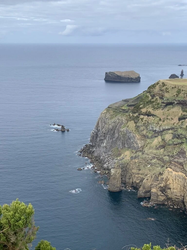 サンミゲル島西海岸の、波が当たる断崖と沖の平たい岩の小島