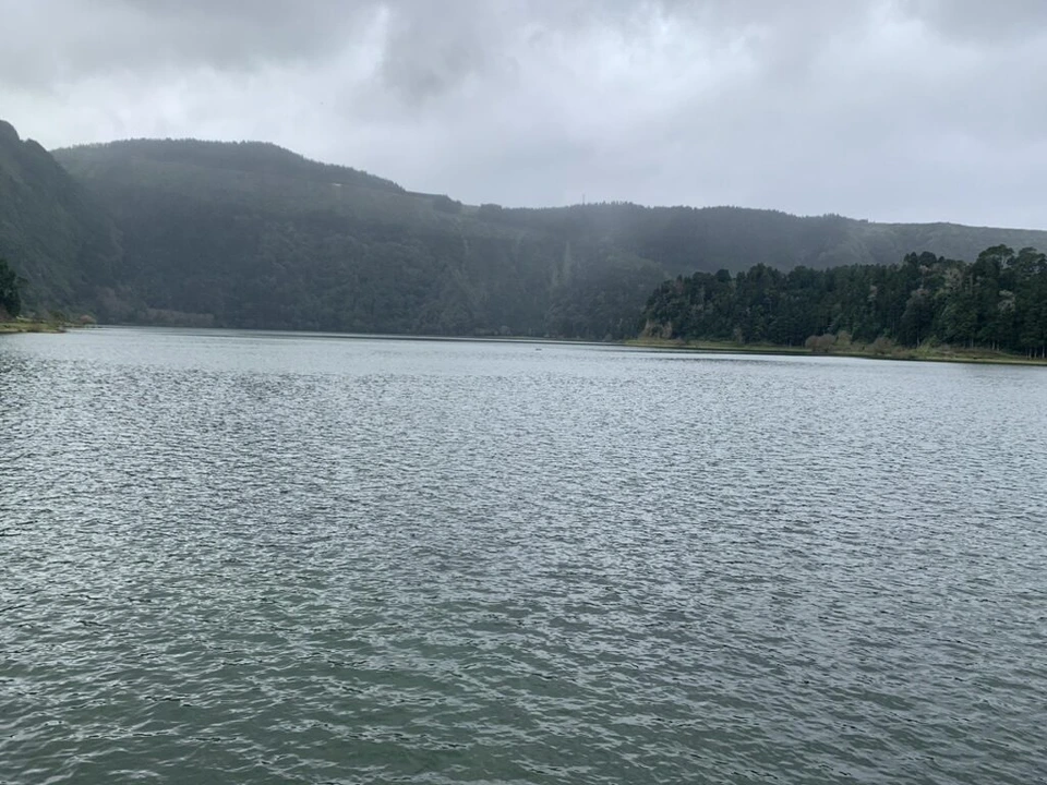 セテ・シダーデスの湖のほとりから見た灰色の水面と対岸の森