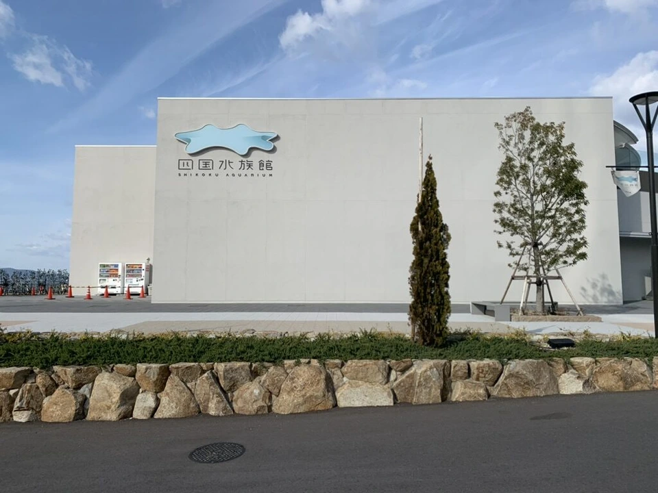 白い壁に四国水族館のロゴが付いた建物の外観と青空