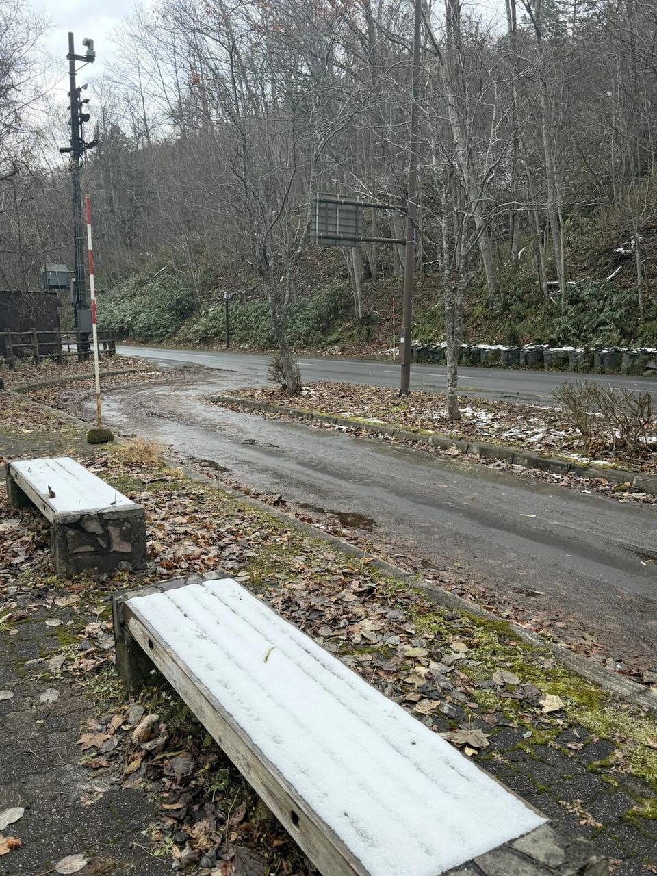 支笏湖畔の雪が積もった木のベンチと道路