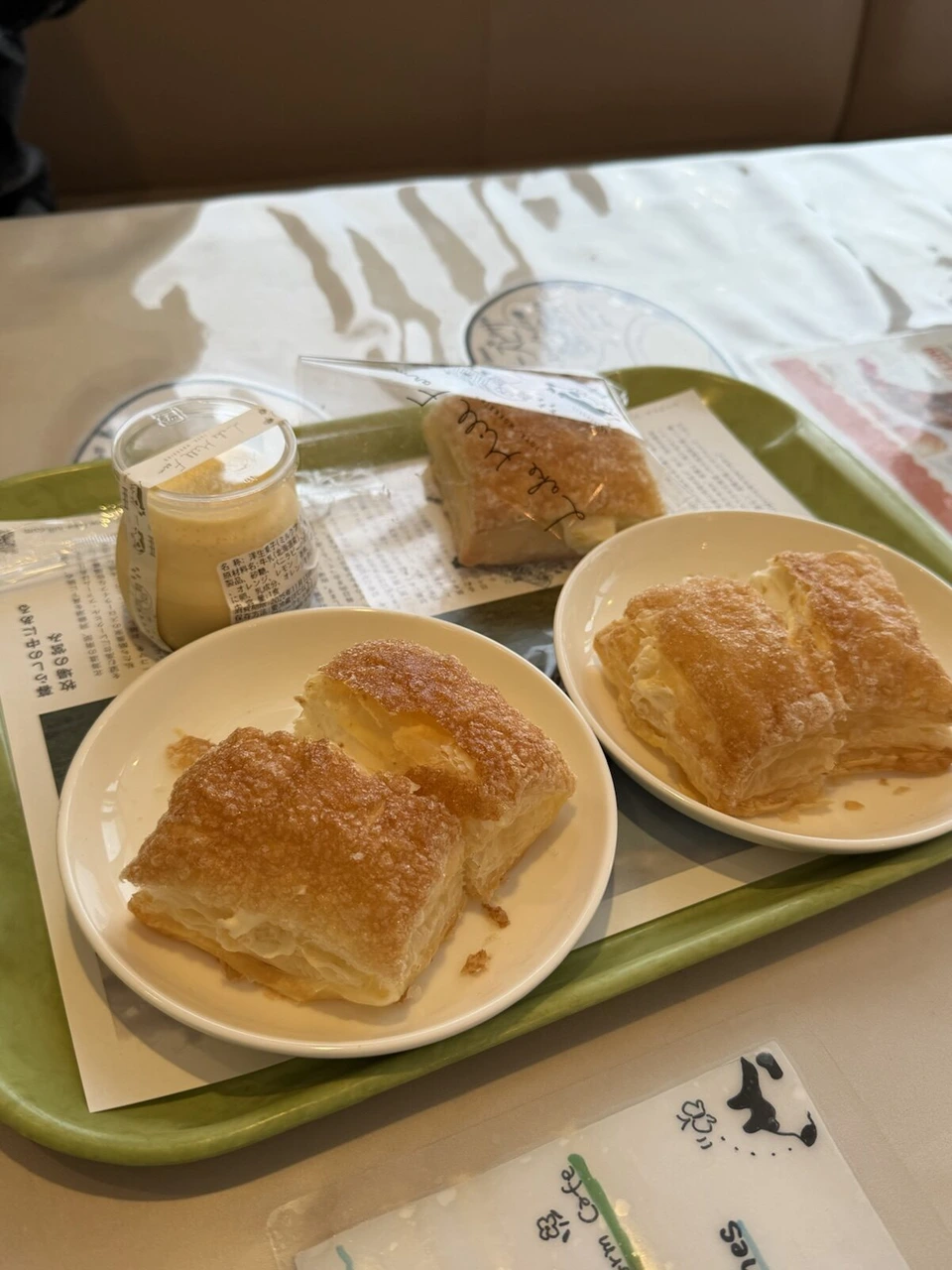 洞爺湖のレークヒル・ファームのカフェで、トレーにのったクリーム入りのパイ2皿、プリン、袋入りのパイ