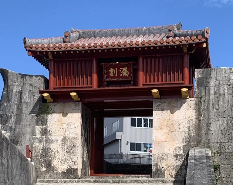 首里城の石垣の間に建つ漏刻門。赤い門に漏刻の扁額