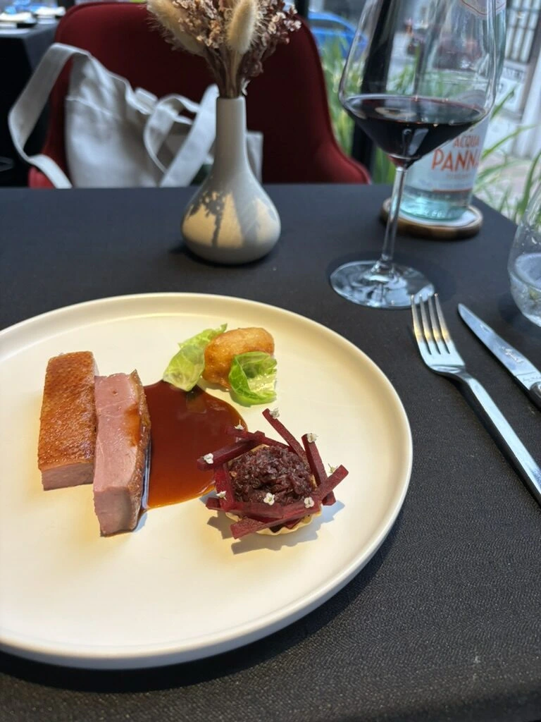 Skillet KLのDiscovery Menuのメインの肉料理、濃いソース、芽キャベツの葉、ビーツのタルト