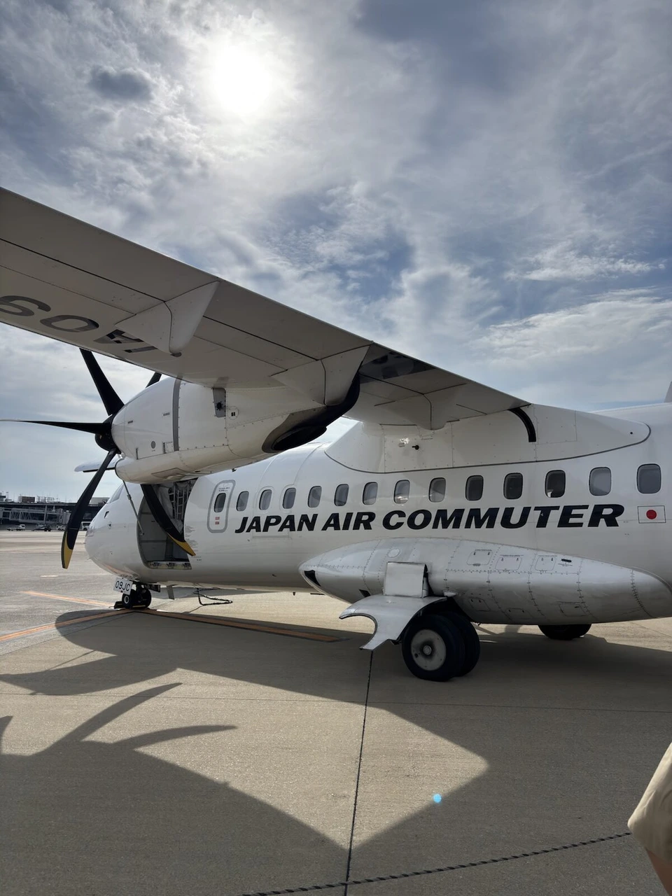 伊丹空港の駐機場で見上げたJAPAN AIR COMMUTERのATR42-600の胴体とプロペラ
