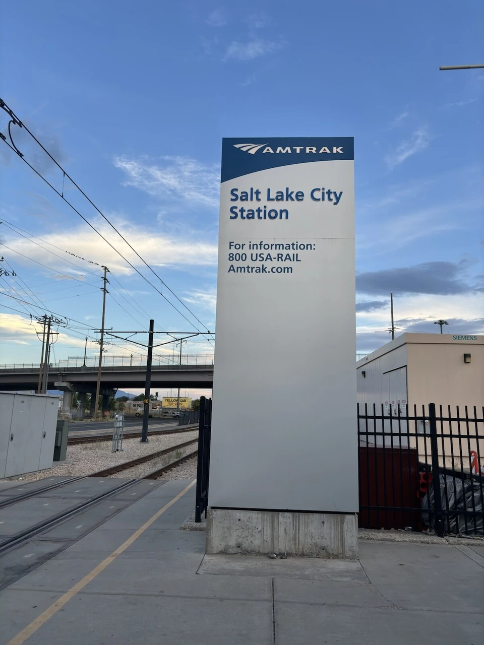 AmtrakのSalt Lake City Stationの案内塔と、FrontRunnerの線路