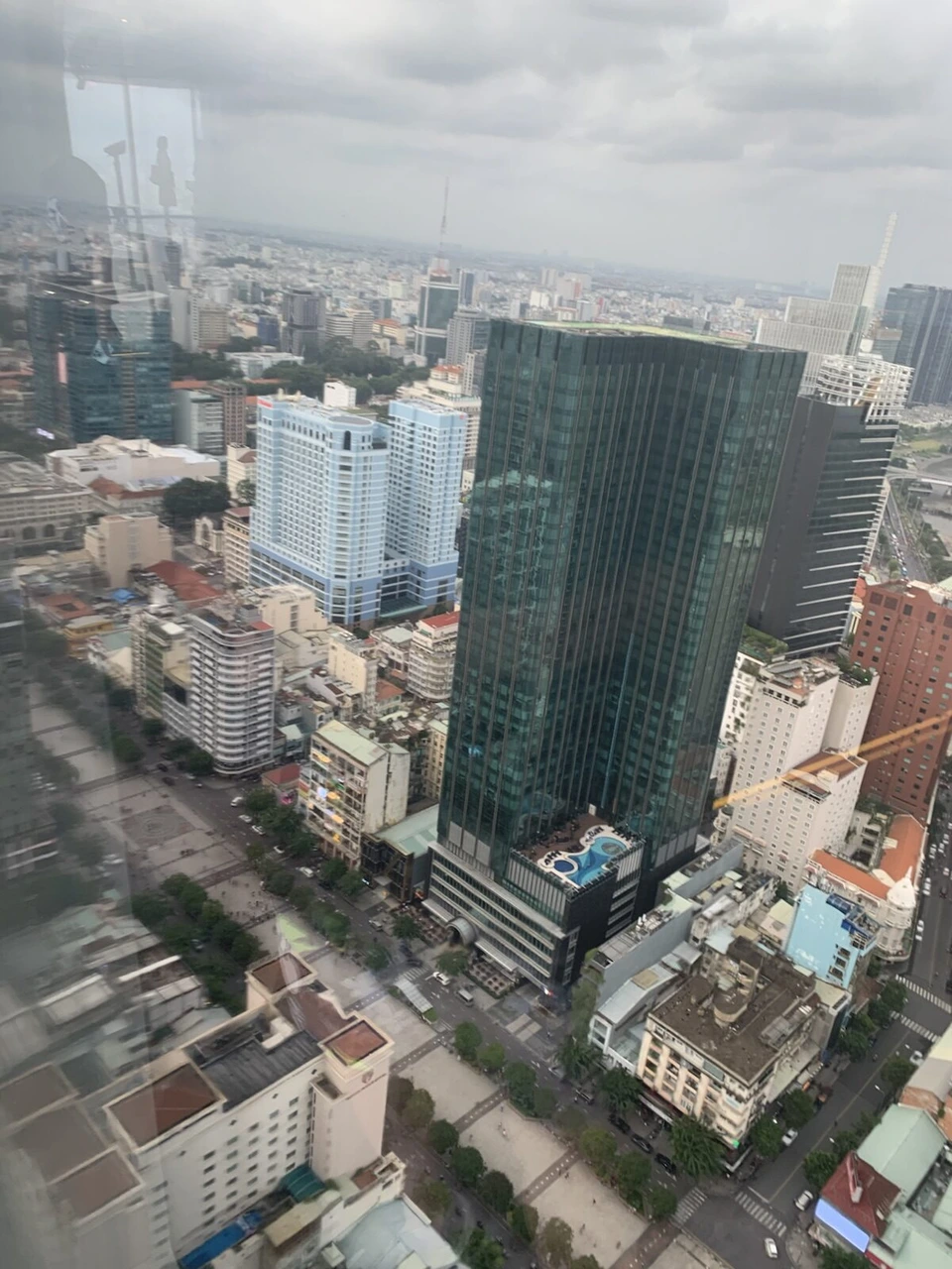 高い建物の窓から見下ろしたホーチミンの街。ガラス張りの高層ビルと低い建物の並ぶ街並み